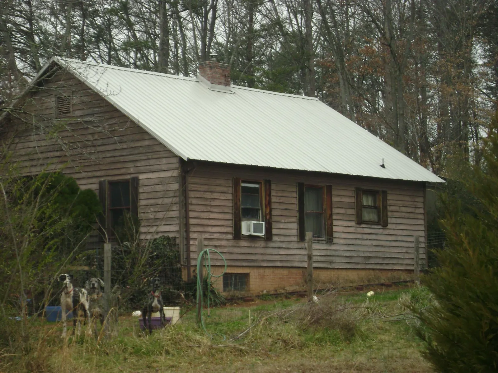 White metal roof on an old wood sided farmhouse, from a Metal Roof Installation job in Enterprise